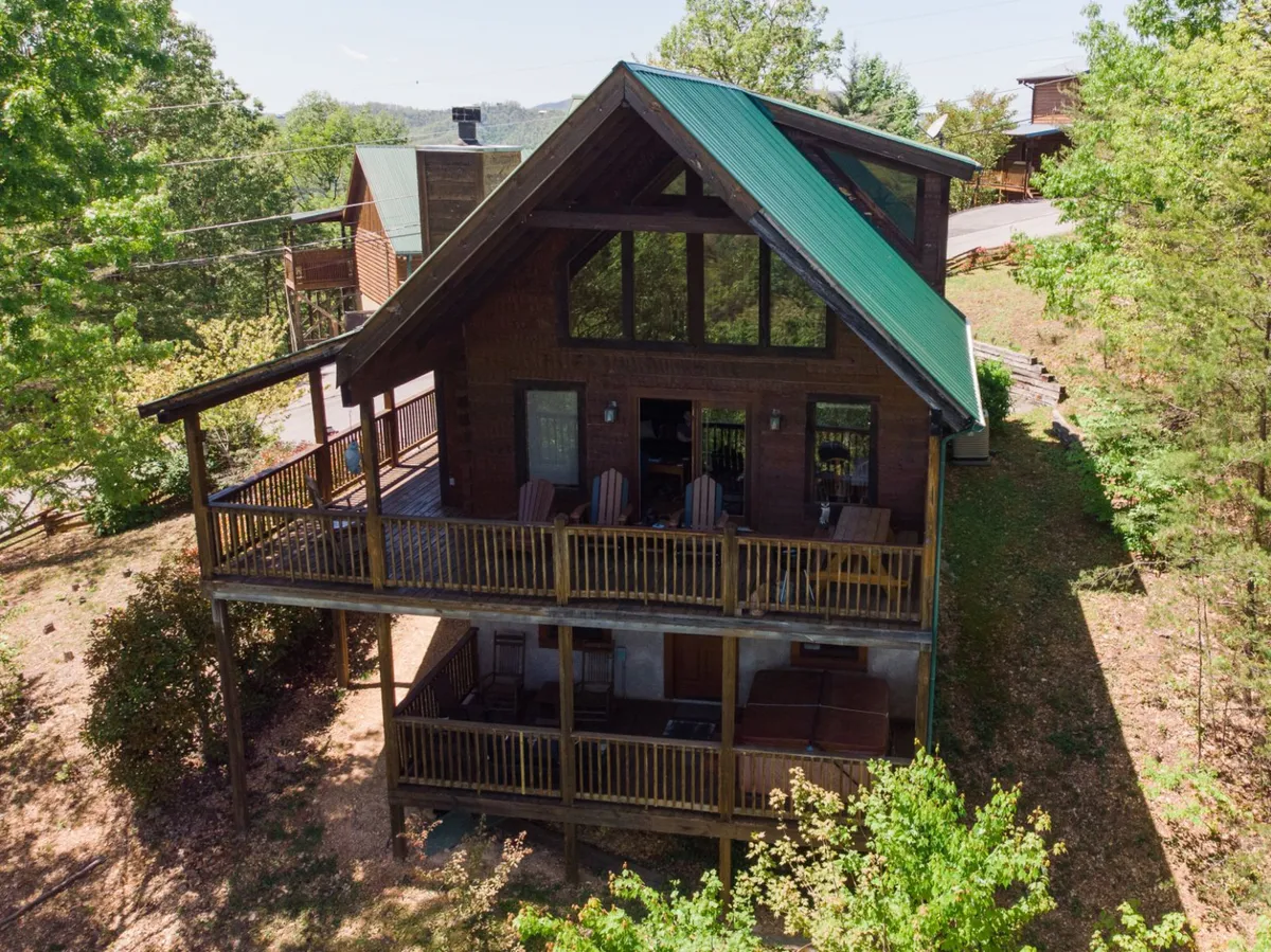 A spacious wooden deck with seating, a green roof, and surrounding trees. The deck is perfect for relaxing after a full day of exploring, or gathering to plan the next day’s attractions.